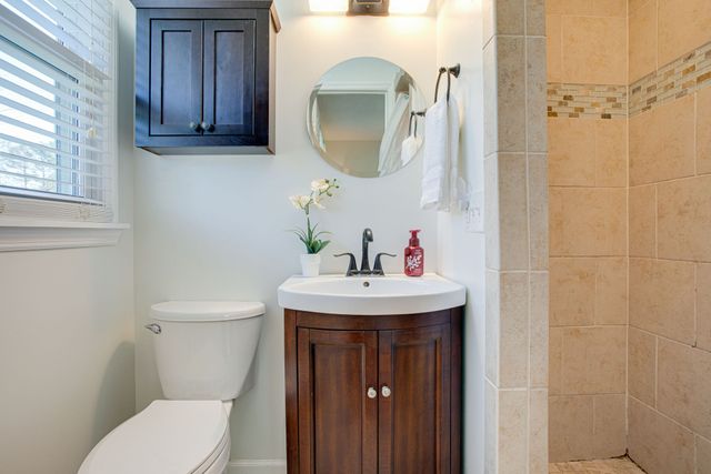 a bathroom with a toilet sink and mirror