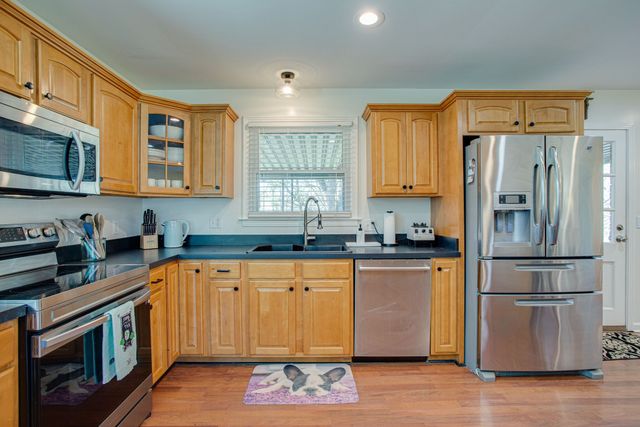 a kitchen with stainless steel appliances granite countertop a refrigerator and a stove top oven