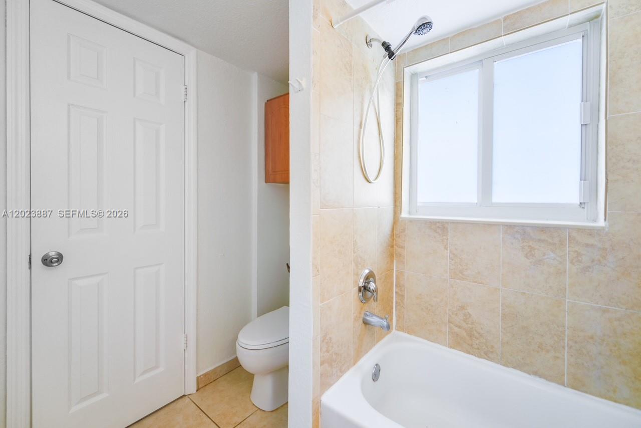 7737 Southwest 88th Street, Unit C312 Miami, FL 33156 - Photo 26 of 32 a bath room with a toilet a bath tub and a shower