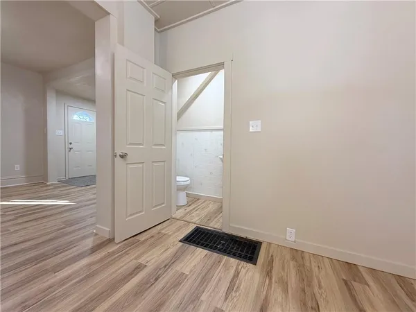 a view of a room with wooden floor and a toilet