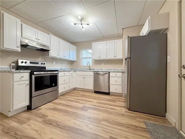 a kitchen with stainless steel appliances granite countertop a stove a refrigerator and a sink with granite countertops
