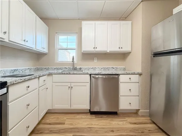 a white kitchen with granite countertop cabinets and a sink