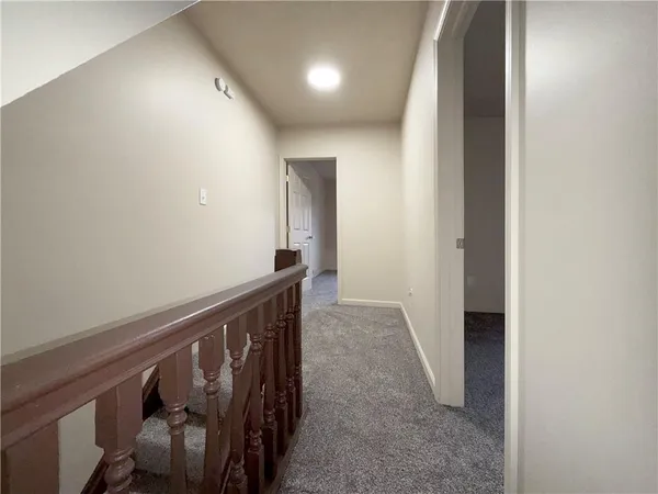a view of a hallway with wooden floor and stairs