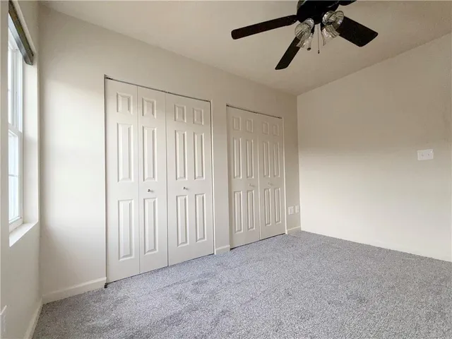 an empty room with a window and a fan