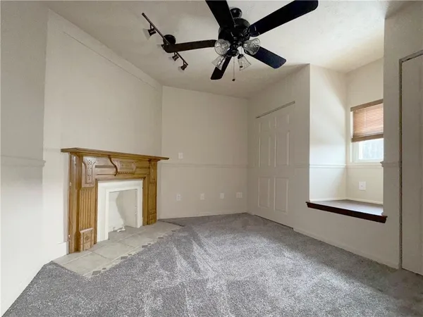 a view of a room with a ceiling fan and a window