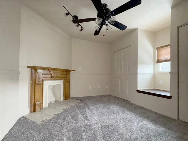 a view of a room with a ceiling fan and a window