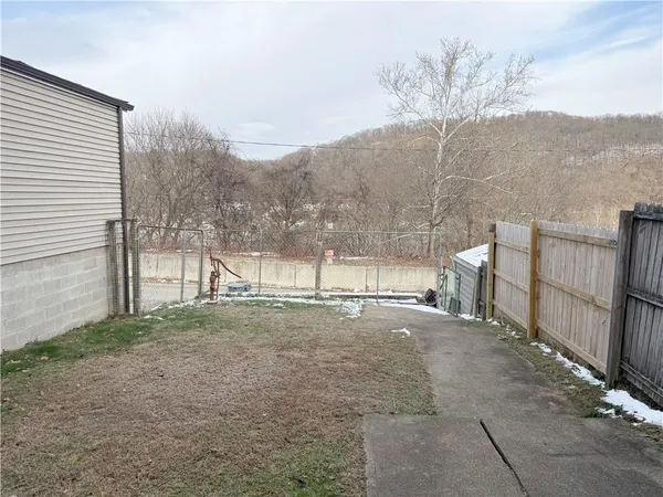 a view of a yard with an house and wooden fence