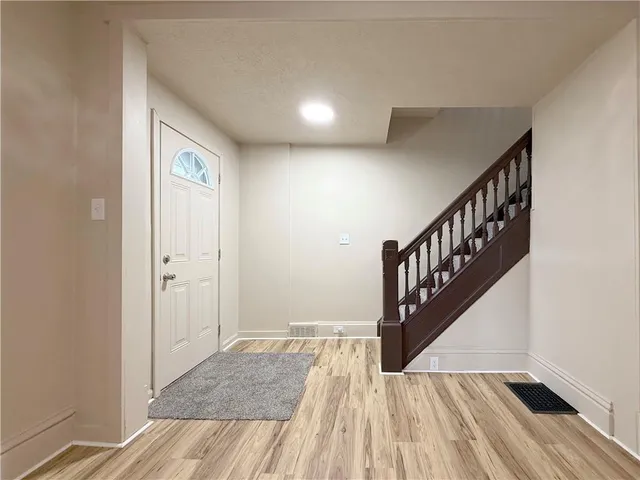 a view of entryway and hall with wooden floor