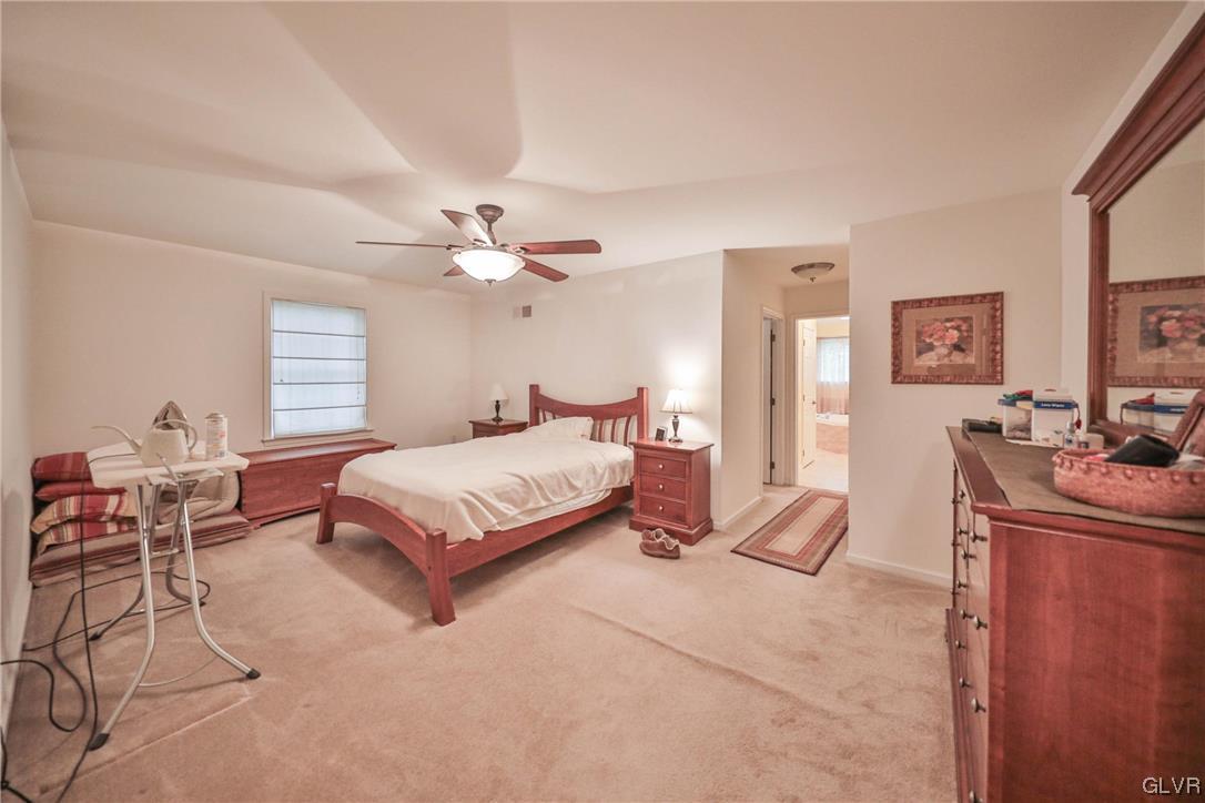 1743 Pen Argyl Road Pen Argyl, PA 18072 - Photo 20 of 38 a spacious bedroom with a bed and a chandelier