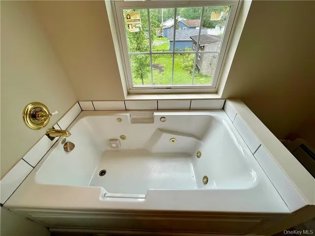 a bathroom with a tub and a window