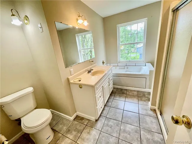 a bathroom with a sink toilet and window