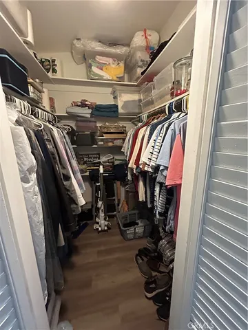 a view of walk in closet with clothes and shoes