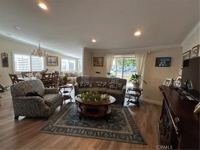 a living room with furniture a rug a window and a flat screen tv