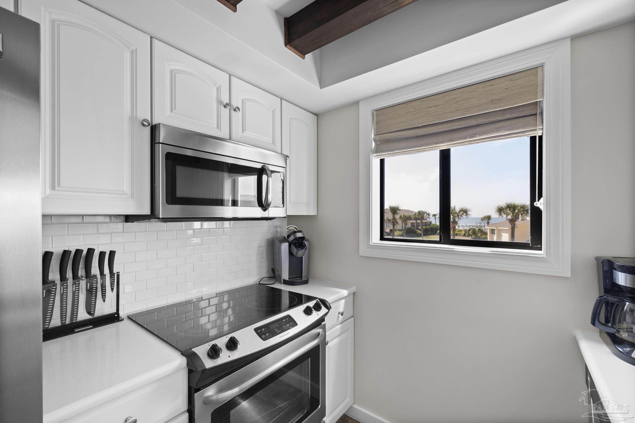 900 Fort Pickens Road, Unit 426 Pensacola Beach, FL 32561 - Photo 15 of 60 a kitchen with stainless steel appliances a stove and a microwave