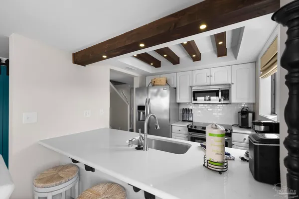 a kitchen with stainless steel appliances granite countertop a sink a stove and a refrigerator