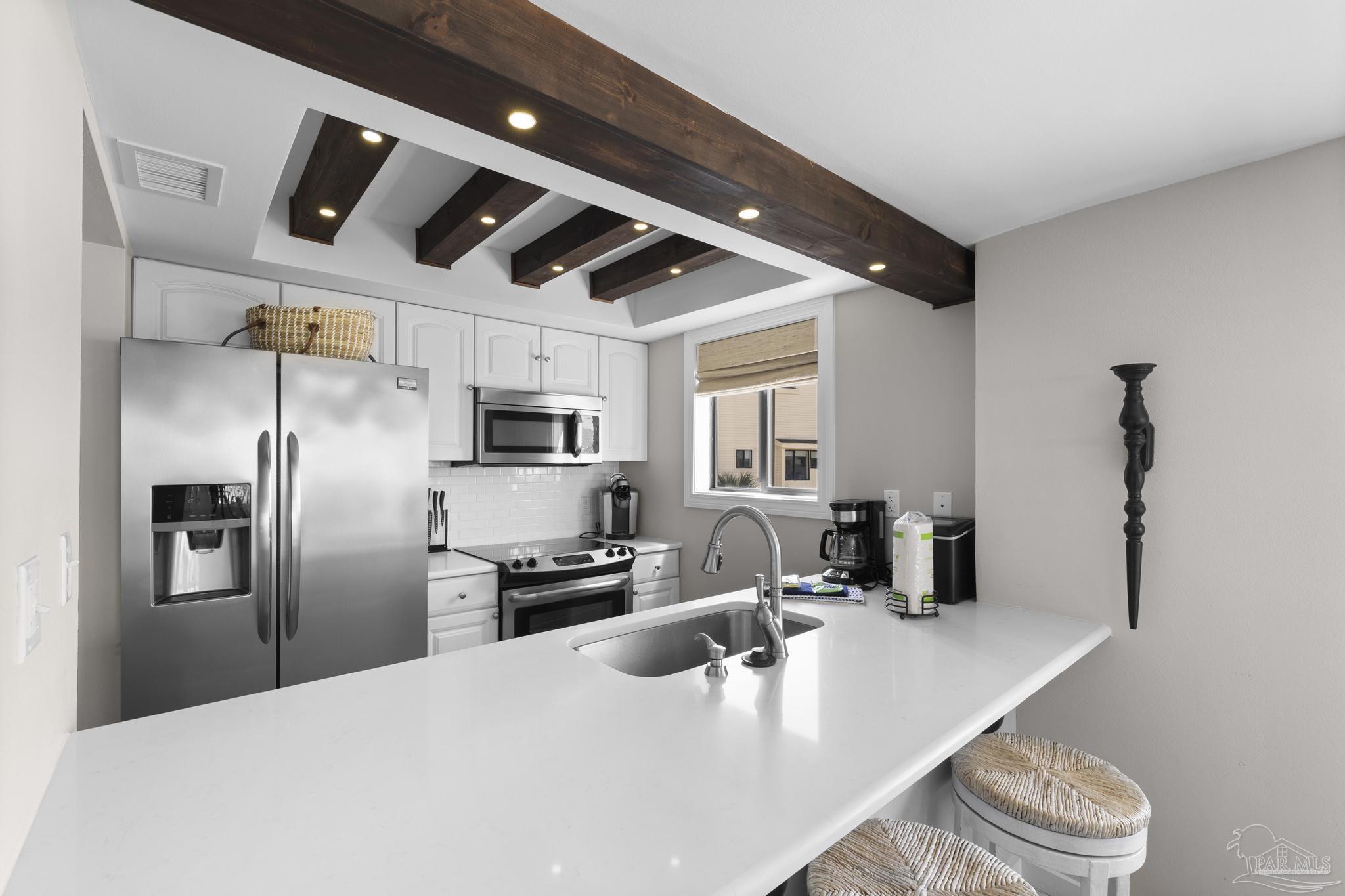 900 Fort Pickens Road, Unit 426 Pensacola Beach, FL 32561 - Photo 19 of 60 a kitchen with stainless steel appliances granite countertop a sink a stove and a refrigerator