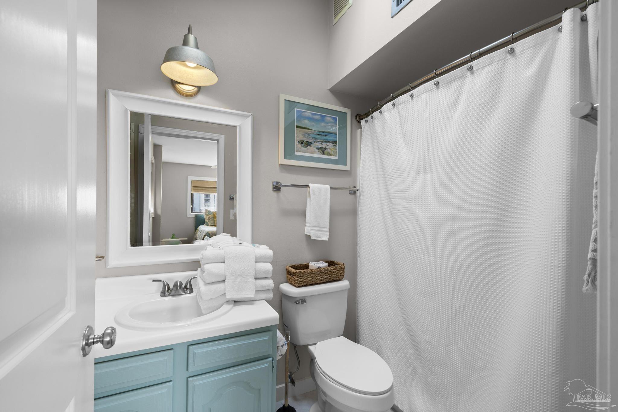 900 Fort Pickens Road, Unit 426 Pensacola Beach, FL 32561 - Photo 27 of 60 a bathroom with a sink a toilet and shower curtain