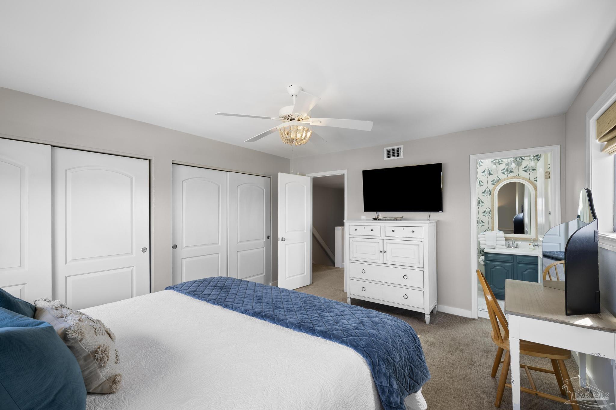 900 Fort Pickens Road, Unit 426 Pensacola Beach, FL 32561 - Photo 29 of 60 a bedroom with a bed a flat screen tv and a chandelier