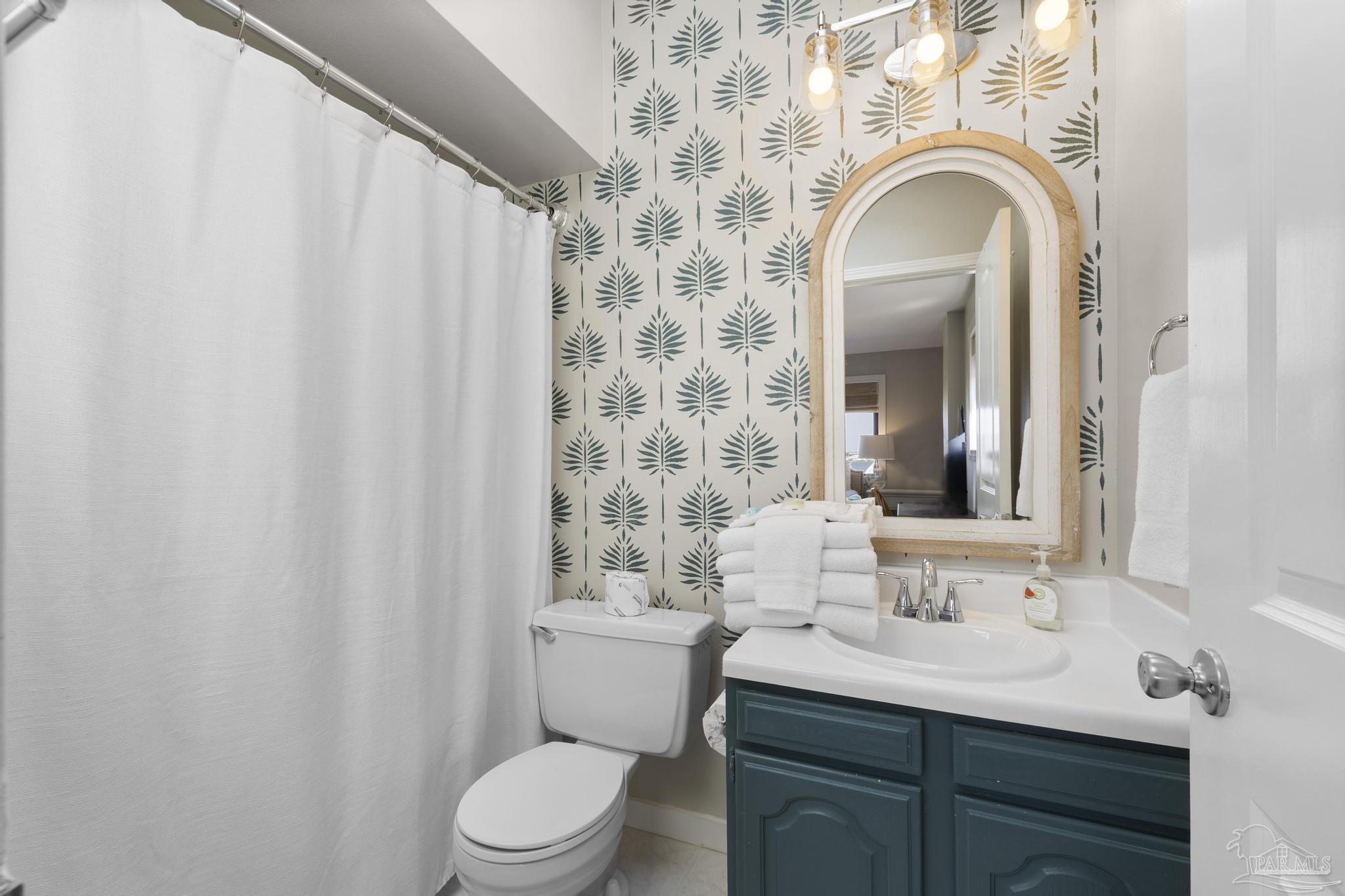 900 Fort Pickens Road, Unit 426 Pensacola Beach, FL 32561 - Photo 30 of 60 a bathroom with a sink a toilet and a mirror
