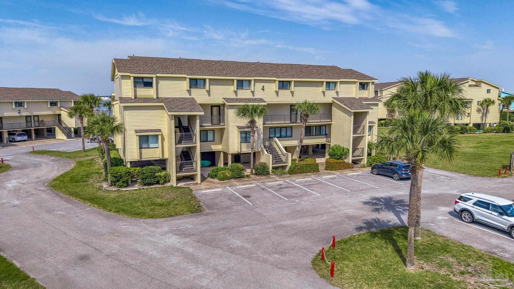 900 Fort Pickens Road, Unit 426 Pensacola Beach, FL 32561 - Photo 39 of 60 a front view of a house with a yard and garage