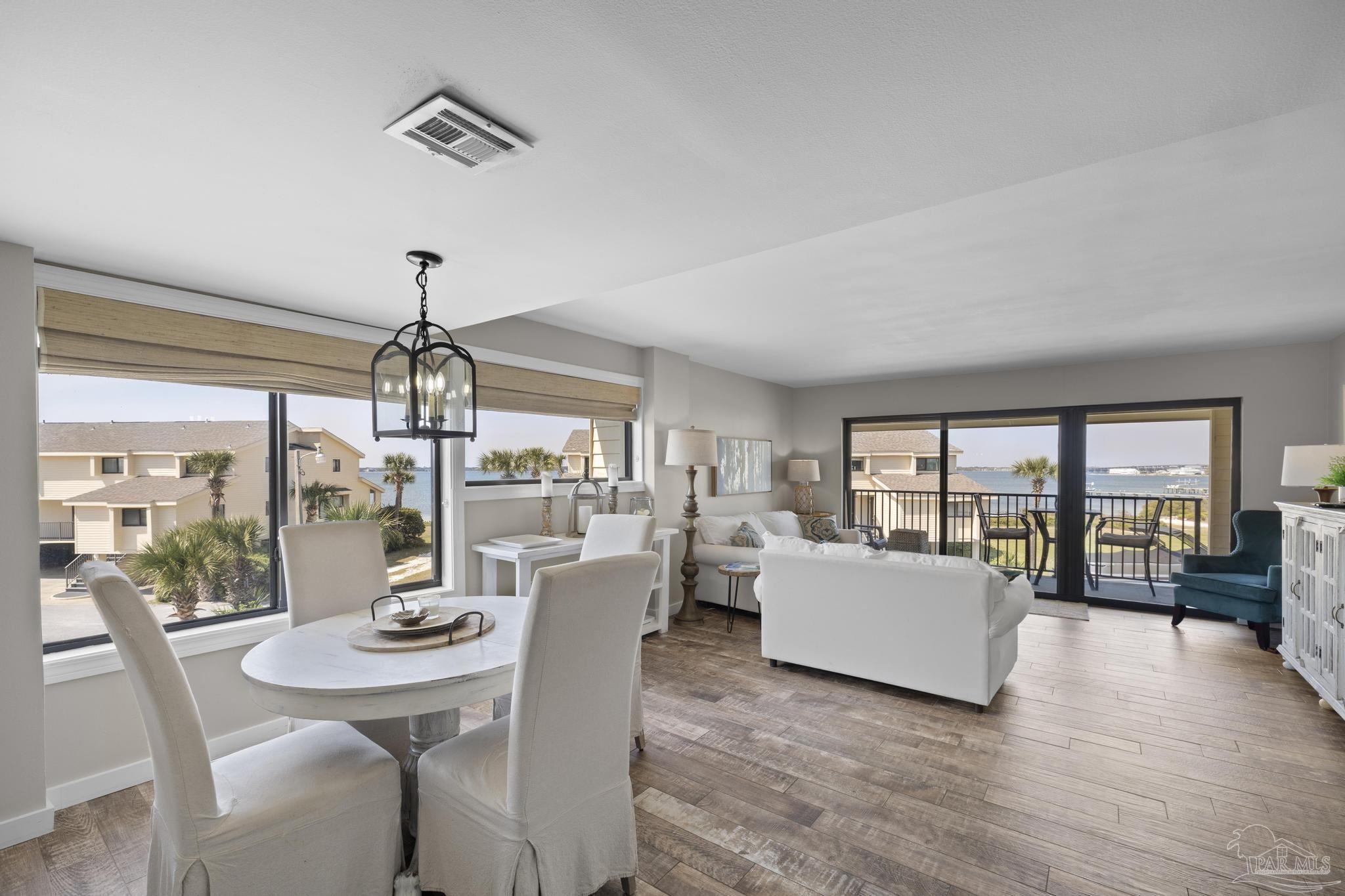 900 Fort Pickens Road, Unit 426 Pensacola Beach, FL 32561 - Photo 7 of 60 a view of a dining room with furniture wooden floor and chandelier