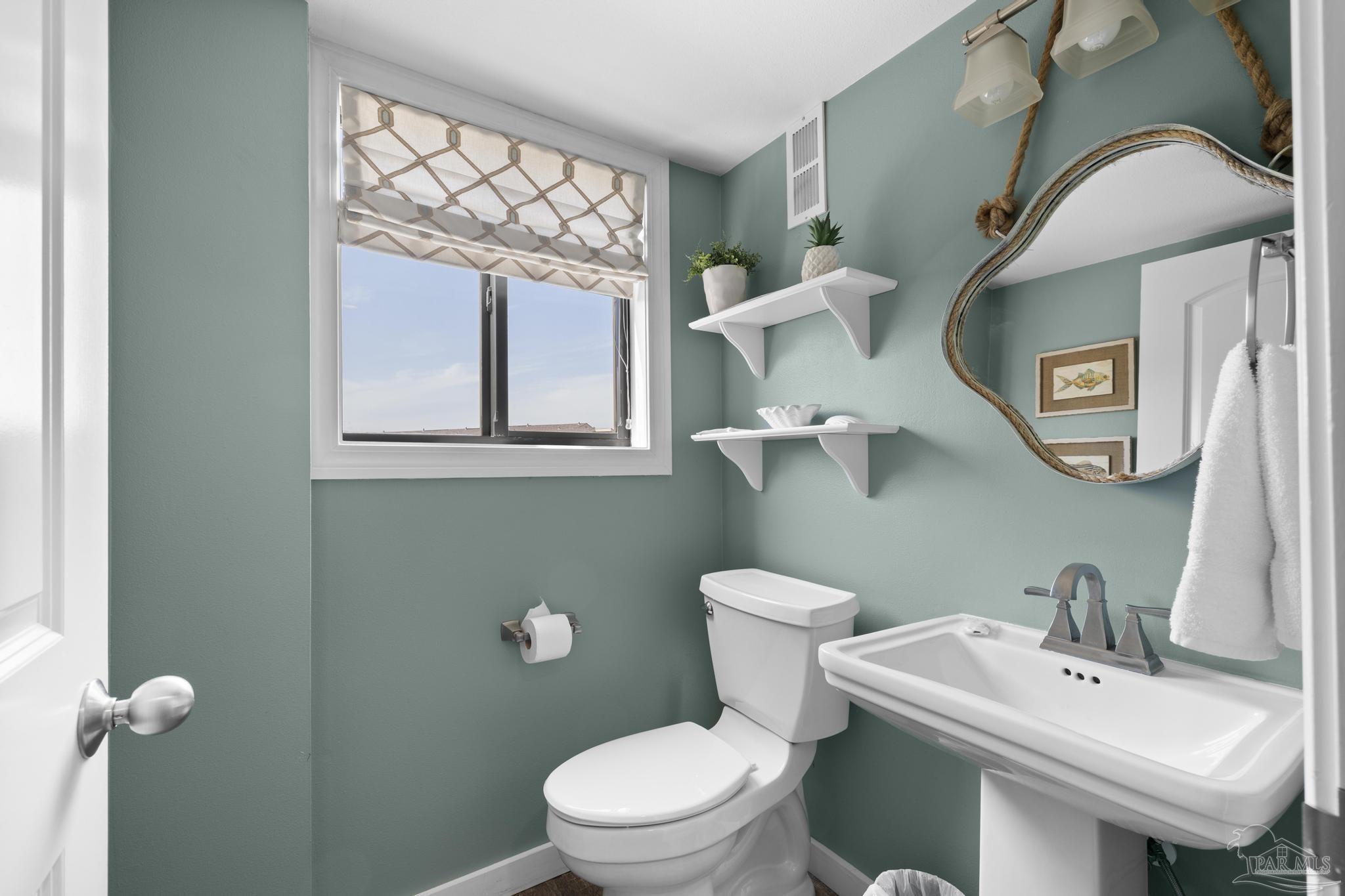 900 Fort Pickens Road, Unit 426 Pensacola Beach, FL 32561 - Photo 9 of 60 a white toilet sitting next to a bathroom sink