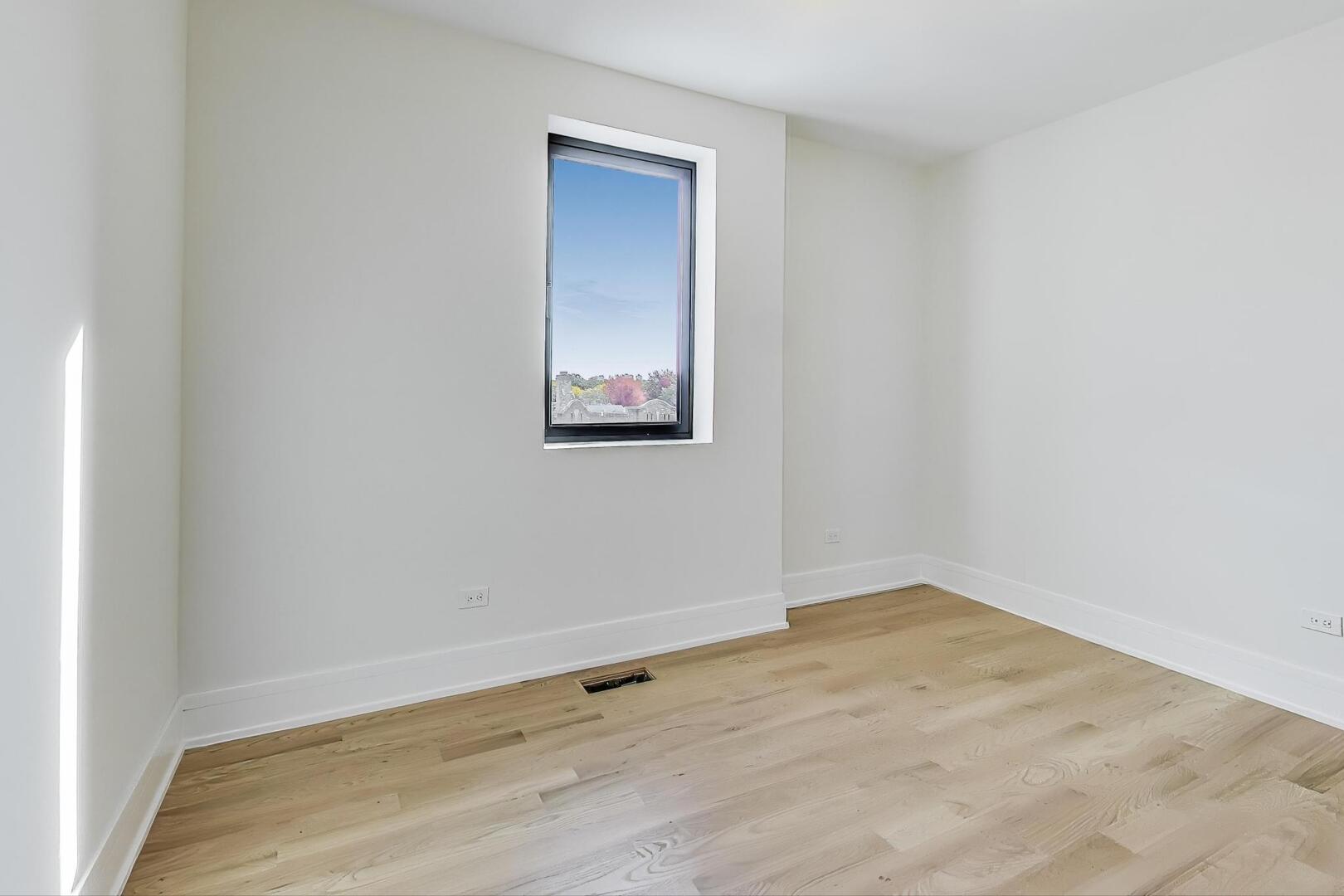 2307 West Foster Avenue, Unit 3 Chicago, IL 60625 - Photo 32 of 48 an empty room with wooden floor and windows