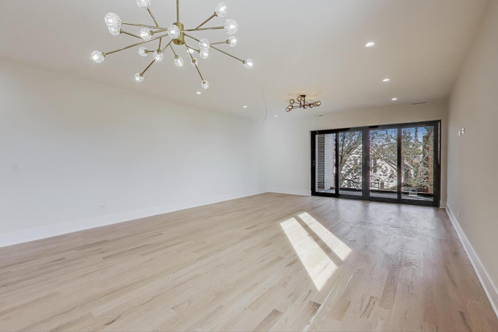 2307 West Foster Avenue, Unit 3 Chicago, IL 60625 - Photo 5 of 48 wooden floor in an empty room with a window