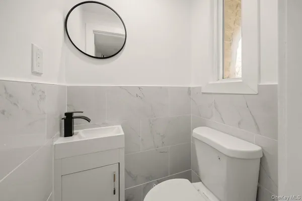 a bathroom with a toilet a sink and a mirror