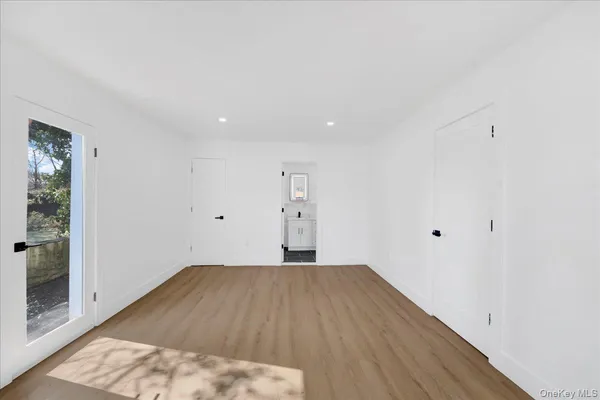 a view of a big room with wooden floor and windows