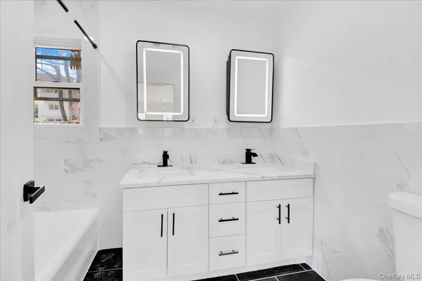 a bathroom with a sink a toilet and a mirror