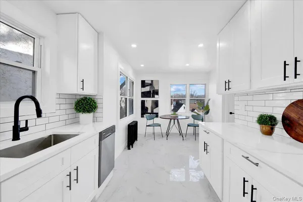 a kitchen with a sink stainless steel appliances and white cabinets