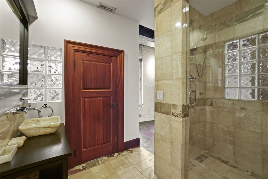 96 South Street, Unit 3 Boston, MA 02111 - Photo 15 of 17 a bathroom with a sink a mirror and shower