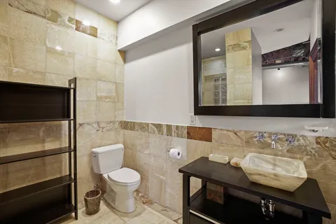 a bathroom with a toilet a sink and mirror