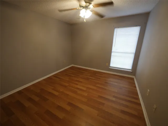 an empty room with a window and a fan