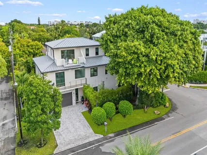 a view of a white house with a yard and plants