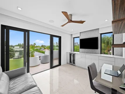 a balcony with wooden floor table and chairs
