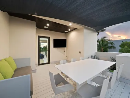 a living room with furniture floor to ceiling window hardwood floor and a flat screen tv