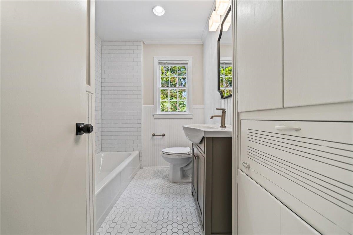 170 South Greer Street Memphis, TN 38111 - Photo 9 of 35 Full bathroom with white subway tile shower surround, hexagonal floor tiles, a window, beadboard wainscoting, and a vanity with an integrated sink
