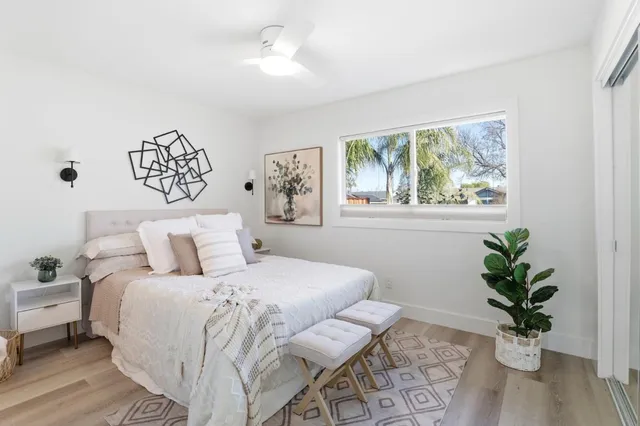 a bedroom with a large bed and a potted plant