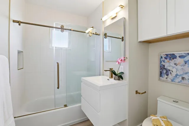 a bathroom with a sink mirror toilet and vanity