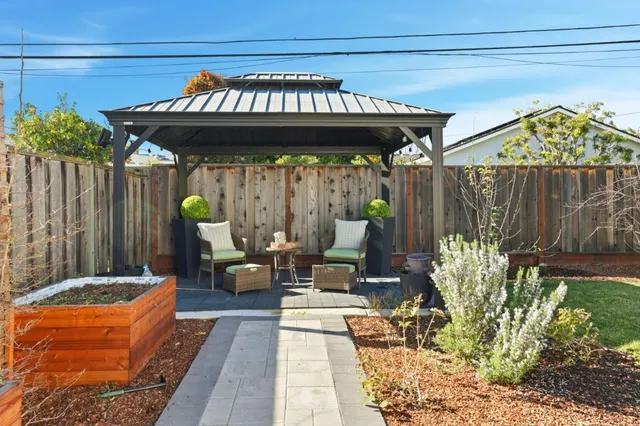 a view of a patio with table and chairs potted plants