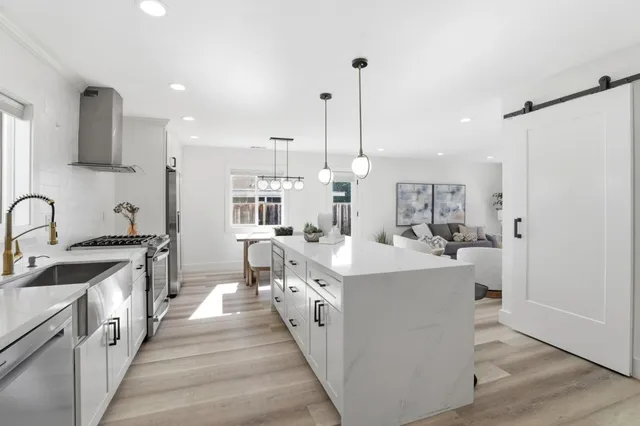 a large kitchen with stainless steel appliances a lot of counter space and a wooden floor