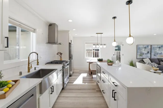 a large kitchen with kitchen island a large counter space a sink stainless steel appliances and cabinets