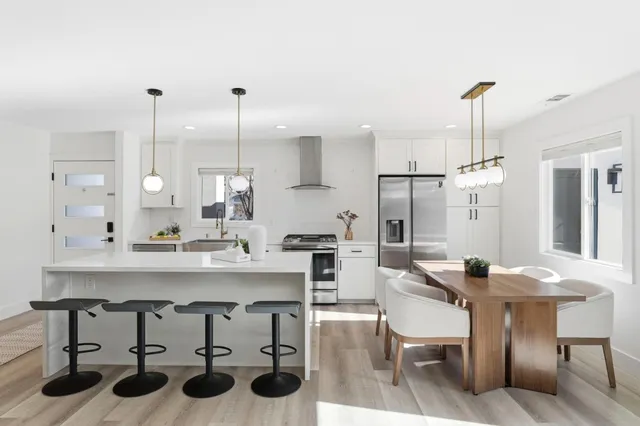 a kitchen with a sink a stove a dining table and chairs