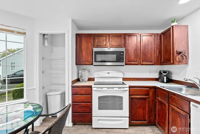 a kitchen with stainless steel appliances wooden cabinets and a stove top oven