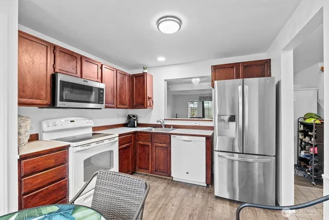 a kitchen with stainless steel appliances granite countertop a refrigerator stove microwave and sink