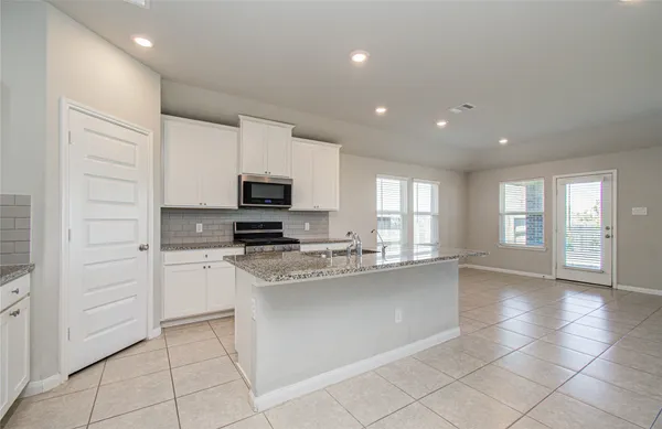 a kitchen with granite countertop a sink stove and cabinets