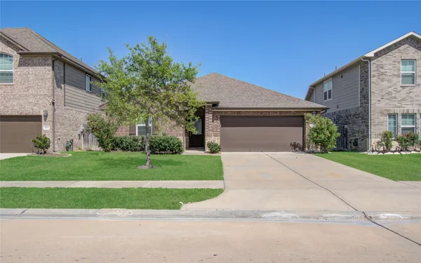 a front view of a house with a yard and trees