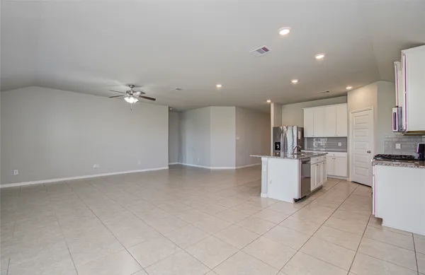 a kitchen with a refrigerator and white cabinets